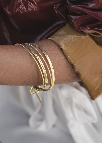 girl wearing,in the right hand,  a gold bangle bracelet by 3rd Floor Coordinates Line