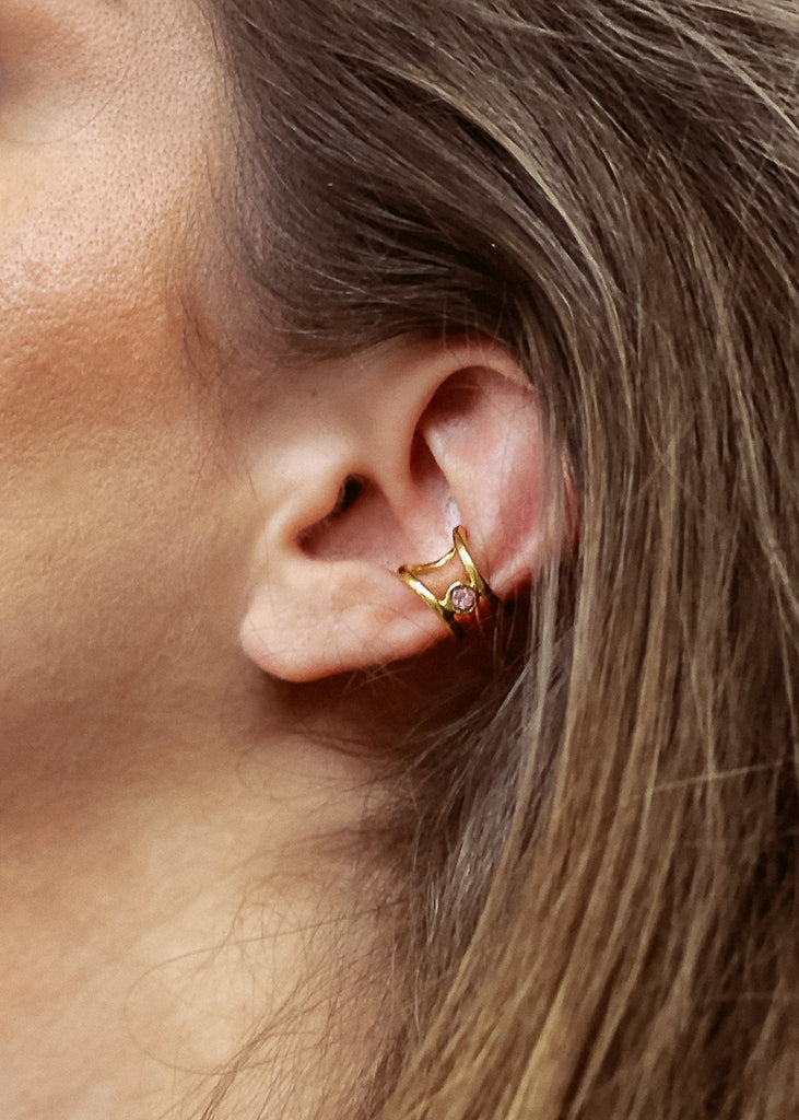 Μοντέλο που φοράει χειροποίητο ear cuff σκουλαρίκι χρυσό με μία πέτρα swarovski ροζ, στο αυτί.