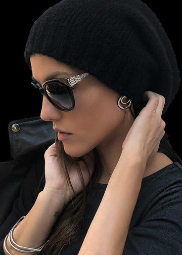 woman with a black beanie and sunglasses is wearing the twins earrings in silver color